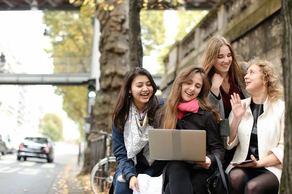 Kvinnliga studenter som sitter på bänken och lärande med laptop och pa — Stockfoto