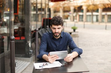 Hoşnutsuz adam online oyun tarafından tablet sokak café'de oynuyor..