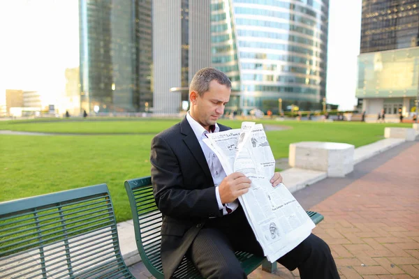 Mannelijke manager Gladden krant buiten in lezen  . — Stockfoto