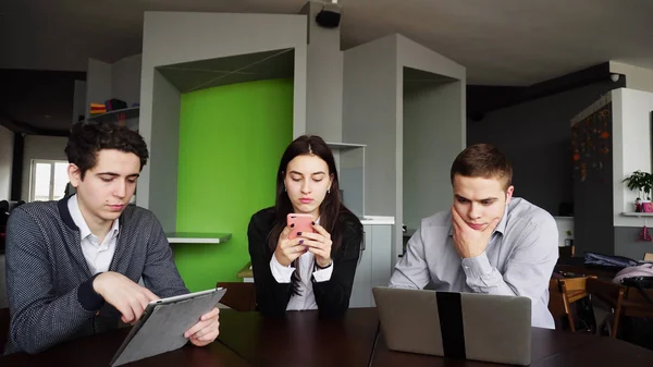 Három munkatársának, a nő és a két fiatal férfi ül a szociális háló — Stock Fotó