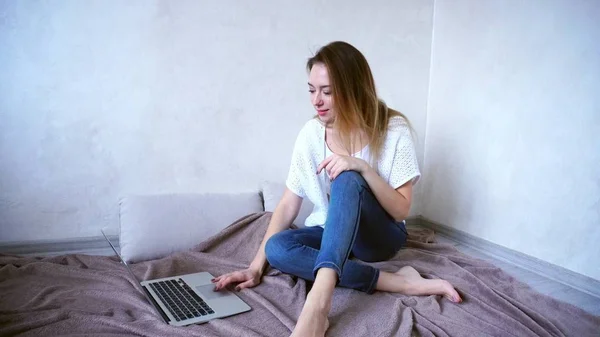 Charmante meisje freelancer werkt thuis op computer, zittend op — Stockfoto
