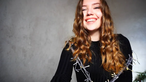 Mujer joven sonriendo, mirando a la cámara con el pelo rizado — Foto de Stock