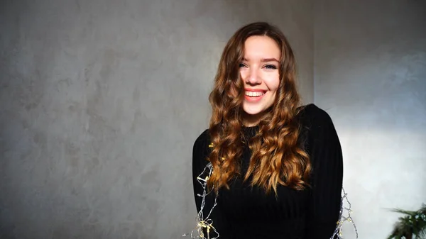 Mujer joven sonriendo, mirando a la cámara con el pelo rizado — Foto de Stock