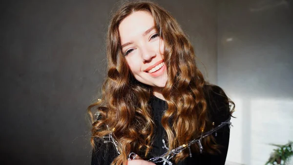 Jovem fêmea sorrindo, olhando para a câmera com cabelo encaracolado — Fotografia de Stock