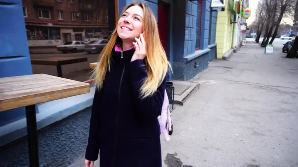 Menina de cabelos bonitos andando na rua e sorrir . — Fotografia de Stock