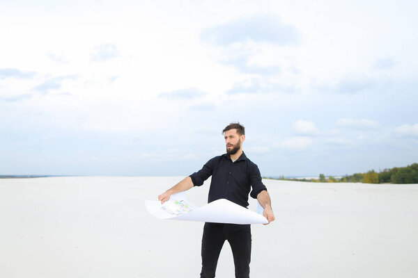   Archeologist man reviewing plan of excavations in village talk