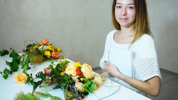 Maravilhoso decorador floral feminino olha para a câmera e sorri, s — Fotografia de Stock