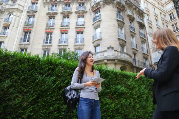 Beautiful girl talking with foreign Chinese student keeping tabl