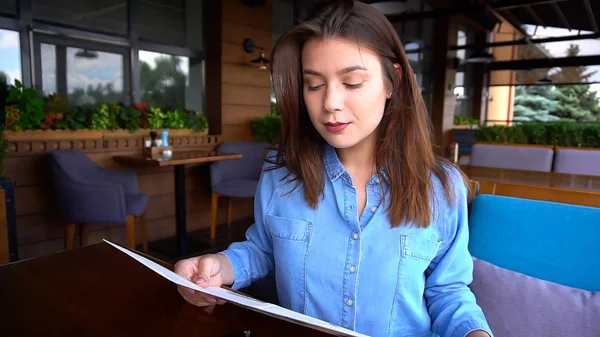 Mujer bonita leyendo menú en el restaurante con la cara de cerca — Foto de Stock