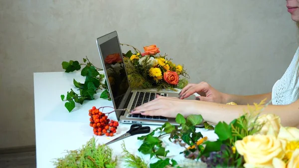 在笔记本电脑上工作的花设计师的手特写 — 图库照片
