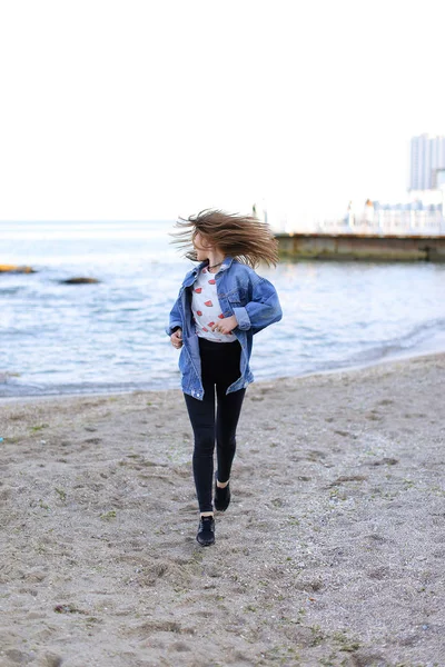 Sevimli kadın gülümseme ile teşkil etmektedir ve deniz kıyı savaş yürür — Stok fotoğraf