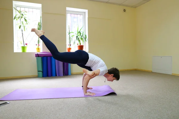 Young beautiful woman sitting on floor on mat for fitness and pe — Stock Photo, Image