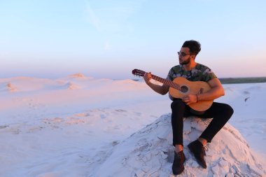 Çekici Arap adam gitar, Hill'de oturan şarkı söylüyor