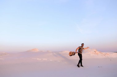 Arap adam çöl güzelliği ile ilham gider ve gitar çi çalış
