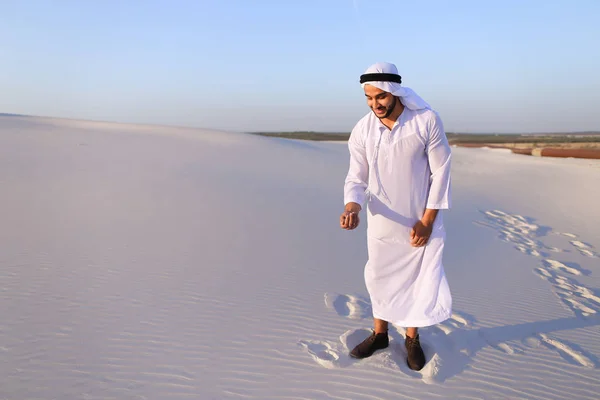 Μουσουλμανική man αναπτύσσει άμμο κατά μήκος άνεμος που στέκεται στη μέση της ερήμου — Φωτογραφία Αρχείου