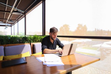 Miktar arazi kafeterya masada kağıtları ve dizüstü bilgisayar ile çalışma.