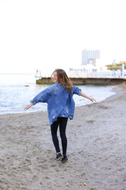 Sevimli kadın gülümseme ile teşkil etmektedir ve deniz kıyı savaş yürür