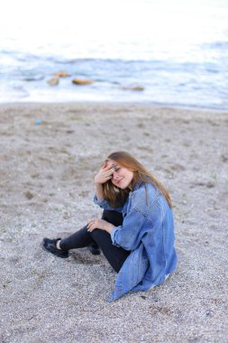 Dinlenme, deniz kenarında oturan ve b kameraya poz güzel kız