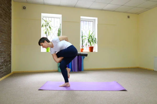 Mulher de aparência europeia envolvida em ioga no estúdio de fitness . — Fotografia de Stock