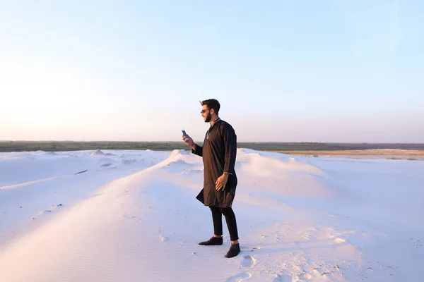 Muslim male tourist speaks on phone and shares news, standing in