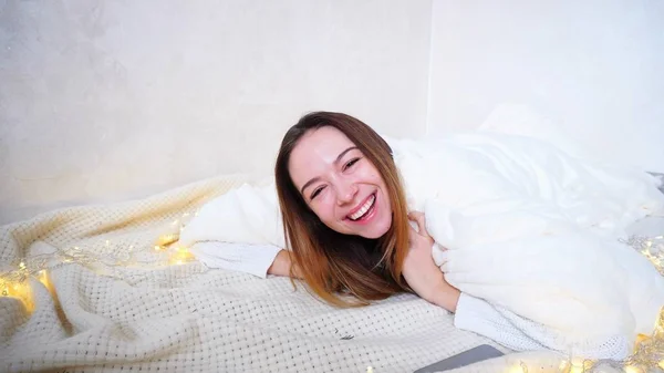 Happy Woman olha para a câmera e sorri, deitado no chão coberto b — Fotografia de Stock