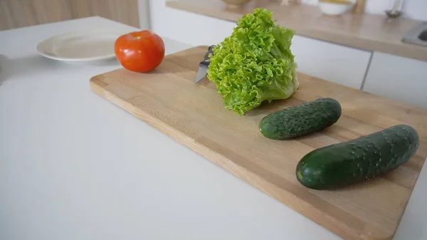 Shooting close-up of fresh vegetables on cutting board and kitch