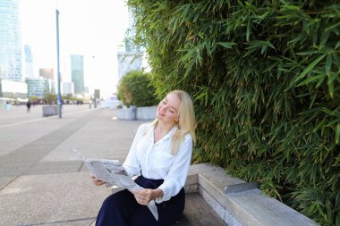 Açık havada yüz yakından ile gazete okuyan Bayan.