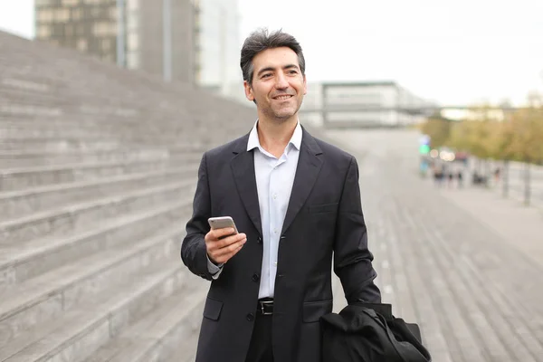 European businessman walking and speaking by telephone.