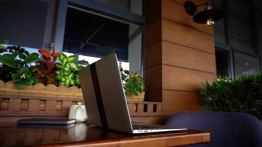 Dizüstü bilgisayar ve Restoran masada siyah defter kapatmak.