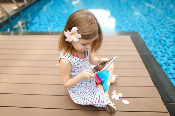 küçük şirin kız kullanır tablet arka plan yüzme havuzunda, nedir