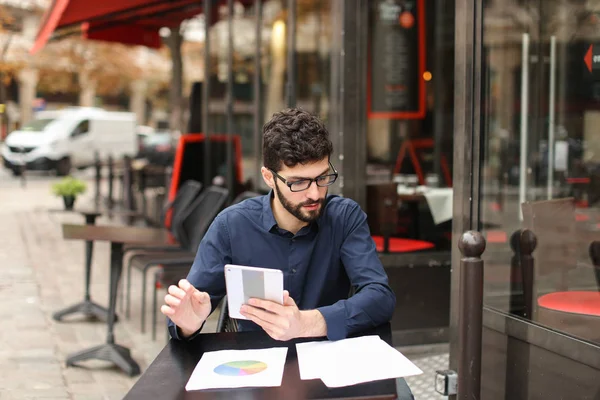 Fresh account manager working with papers and tablet at cafe tab