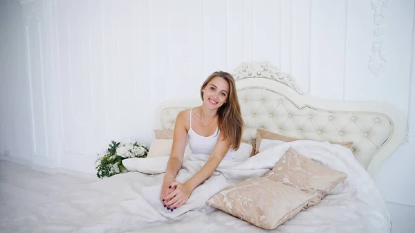 La encantadora dama se relaja después del duro día y descansa acostada en la cama debajo de B — Foto de Stock