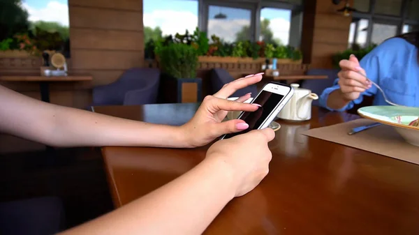 Close up hands with long nails browsing by smartphone at cafe du — Stock Photo, Image