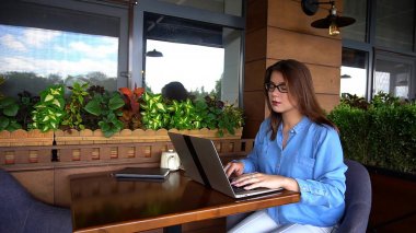 Kadın yazarı dizüstü restoranda makale yazmaya.