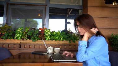 Güzel kız kafede dizüstü bilgisayar tarama.