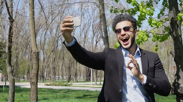 Muslim boy testing new phone and showing peace sign hand — Stock Photo, Image