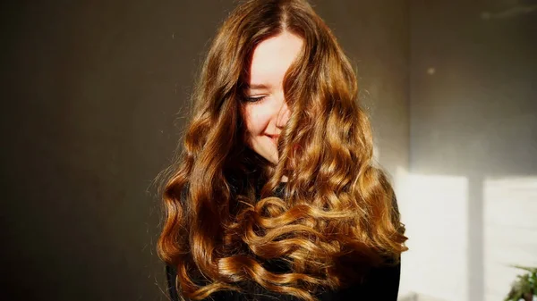 Jovem fêmea sorrindo, olhando para a câmera com cabelo encaracolado — Fotografia de Stock