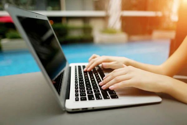 Primer plano retrato de las manos de la mujer presionando los botones del teclado en la piscina día soleado portátil — Foto de Stock