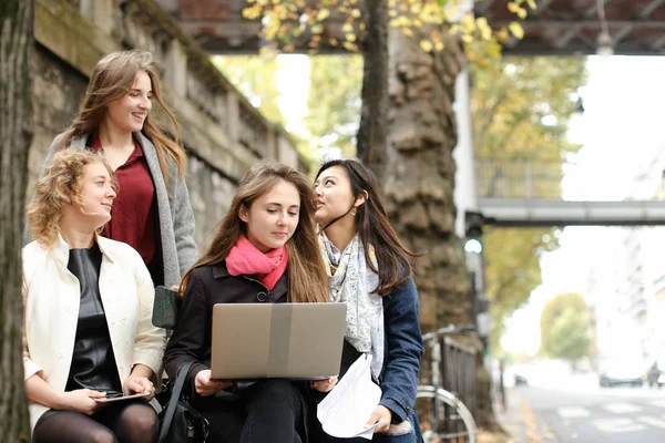 Étudiants européens apprenant avec ordinateur portable et papiers, assis sur être — Photo