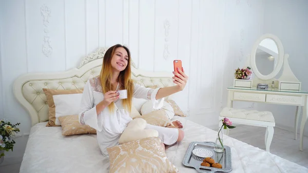 Meisje van aantrekkelijke verschijning maakt Selfie op de voorzijde van de Camera van de Smartphone, — Stockfoto