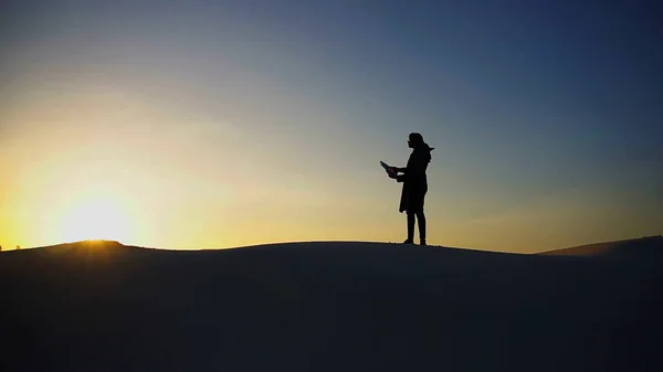 Ανύψωση αρσενικό μουσουλμάνων στην κορυφή της αμμόλοφους πέρα από λευκή άμμο στο — Φωτογραφία Αρχείου