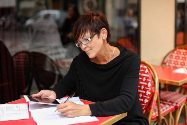  Orta yaşlı kadın tasarımcı kullanım küçük tablet ikrar