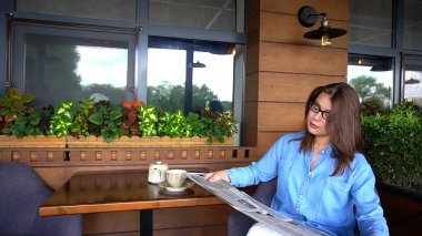 Restoranda gazete okuma ve çay içme büyüleyici kadın 