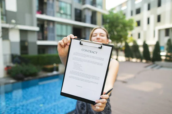 Mano de la mujer se ofrece a firmar el contrato en el contexto de — Foto de Stock