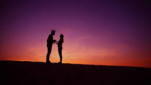 Cheerful guy and girl having fun and dancing on top of sand dune — Stock Photo, Image