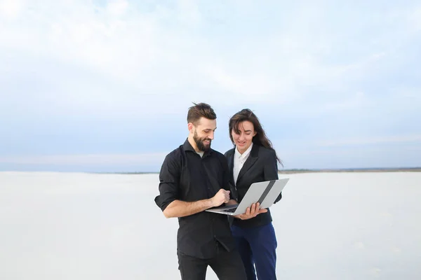 Журналісти чоловік і жінка використовують ноутбук для підготовки репортажу в — стокове фото