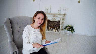 Sevimli kadın Sekreter Holding Kağıt ve çizim eller, kameraya bakıyor ve