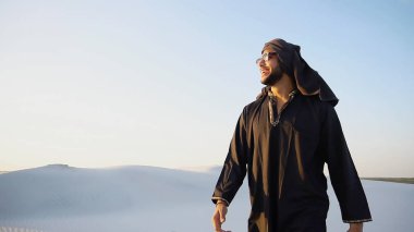 Mutlu Emirliği insan çöl eteklerinde fac gülümseme ile yürüyor