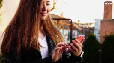 Güzel kız smartphone gr yakınındaki pembe durumda mesaj yazmaya