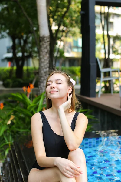 Mujer joven disfrutar, relajarse cerca de palmeras y edificio de apartamentos en — Foto de Stock